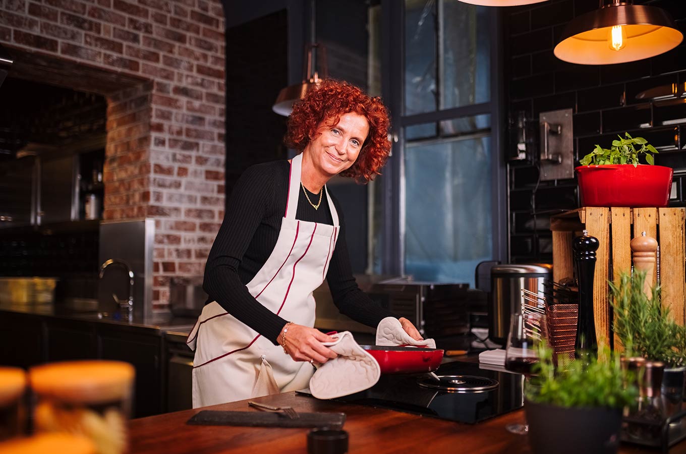 le tablier | rothaarige Frau mit beiger Schürze in der Küche